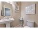 Well-lit half bathroom with a pedestal sink and modern fixtures at 9655 Shadow Cliff Ave, Las Vegas, NV 89166