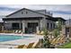 Community pool with lounge chairs and a covered outdoor seating area next to a modern designed clubhouse at 9655 Shadow Cliff Ave, Las Vegas, NV 89166