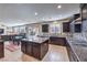 Spacious kitchen with dark cabinetry, granite countertops, island, and open to the dining area at 9655 Shadow Cliff Ave, Las Vegas, NV 89166