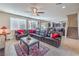 Expansive living room with a large sectional, tile flooring, and stairs to the upper level at 9655 Shadow Cliff Ave, Las Vegas, NV 89166