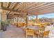 Spacious covered patio featuring brick flooring, wood furnishings and views of the neighborhood and the common amenities at 9655 Shadow Cliff Ave, Las Vegas, NV 89166