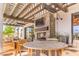 Relaxing covered patio with an outdoor fireplace, mounted tv, comfortable wood furniture, and lush plant accents at 9655 Shadow Cliff Ave, Las Vegas, NV 89166