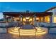 Gorgeous evening view of a covered patio with a stone fireplace and illuminated stairs leading to outdoor seating areas at 9655 Shadow Cliff Ave, Las Vegas, NV 89166