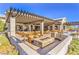 Inviting outdoor patio with fire pit, pergola, and ample seating perfect for entertaining guests on a sunny day at 9655 Shadow Cliff Ave, Las Vegas, NV 89166