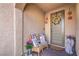 Inviting porch with seating, flowers, and a decorative wreath on the front door at 9655 Shadow Cliff Ave, Las Vegas, NV 89166