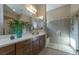 Modern bathroom with a glass-enclosed shower, neutral tile, and a double sink vanity with quartz countertop at 967 Buggy Whip Ct, Mesquite, NV 89034