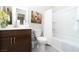 Bathroom showcases a single sink vanity with brown cabinets and a shower-tub combo with a white curtain at 967 Buggy Whip Ct, Mesquite, NV 89034