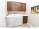 Well-equipped laundry room featuring modern washer, dryer, cabinetry, and neutral tiling at 967 Buggy Whip Ct, Mesquite, NV 89034