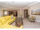 Bright living room featuring a yellow sectional, decorative table, and open access to the kitchen at 967 Buggy Whip Ct, Mesquite, NV 89034