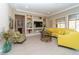 Spacious living room features a yellow sectional, a decorative table, and built-in shelving with a TV at 967 Buggy Whip Ct, Mesquite, NV 89034