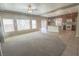 Spacious open-concept living room with plush carpeting adjacent to a modern kitchen featuring an island at 9870 Giant Steps Ct, Las Vegas, NV 89141