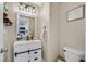 Charming powder room with white vanity, sliding door accent, and industrial-style lighting at 9972 Trailing Vine St, Las Vegas, NV 89183