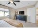 Stylish main bedroom featuring dark wood dresser and shelf, with natural light and soft carpet at 9972 Trailing Vine St, Las Vegas, NV 89183