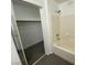 Bathroom featuring a bathtub with tiled walls, and connected open closet behind sliding doors at 10047 Fine Fern St, Las Vegas, NV 89183