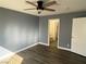 Comfortable bedroom with wood flooring, ceiling fan, and a connecting bathroom at 10047 Fine Fern St, Las Vegas, NV 89183