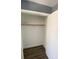 A closet with a white interior, brown wood floors, and a rod for hanging clothes at 10047 Fine Fern St, Las Vegas, NV 89183
