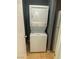 Clean laundry room with a stacked washer and dryer next to a white refrigerator at 10047 Fine Fern St, Las Vegas, NV 89183