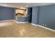 An open-concept kitchen and living room with gray walls and neutral ceramic tile flooring at 10047 Fine Fern St, Las Vegas, NV 89183