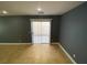 A living room featuring neutral ceramic tile, gray walls, and sliding glass doors at 10047 Fine Fern St, Las Vegas, NV 89183