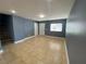 Open-concept living room with tile floors and neutral-colored walls for a modern and spacious feel at 10047 Fine Fern St, Las Vegas, NV 89183