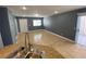 A living room featuring neutral ceramic tile, gray walls, and white kitchen cabinets in the background at 10047 Fine Fern St, Las Vegas, NV 89183