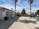 Community pool with restroom, surrounded by mature palm trees and nearby residential buildings at 10047 Fine Fern St, Las Vegas, NV 89183