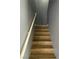 A wooden staircase with a white handrail ascends to the upper level of the home at 10047 Fine Fern St, Las Vegas, NV 89183