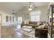 Spacious living room with vaulted ceilings, ceiling fans, wood floors and access to the dining area at 1099 Sheer Paradise Ln # 1, Henderson, NV 89002
