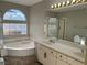 Bright bathroom featuring a soaking tub, glass shower, and dual sink vanity at 11009 Royal Highlands St, Las Vegas, NV 89141