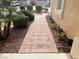 Charming brick walkway leads to the front door, framed by lush landscaping and mature plants at 11009 Royal Highlands St, Las Vegas, NV 89141