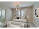 Staged bedroom with neutral tones, a unique lighting fixture and modern decor at 11396 Ogden Mills Dr # 101, Las Vegas, NV 89135