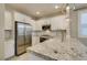 Well-lit kitchen features stainless steel appliances, granite countertops, and white cabinetry at 11396 Ogden Mills Dr # 101, Las Vegas, NV 89135