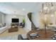 Spacious living room with a cozy seating arrangement, a modern entertainment center, and a dining area with a well-set table at 11396 Ogden Mills Dr # 101, Las Vegas, NV 89135