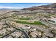 An aerial view captures homes alongside a golf course with mountain backdrops at 1320 Enchanted River Dr, Henderson, NV 89012