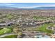 An aerial view showcases an expansive community surrounded by a golf course at 1320 Enchanted River Dr, Henderson, NV 89012