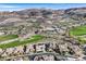 Aerial view showing the golf course and properties nestled in the mountains at 1320 Enchanted River Dr, Henderson, NV 89012