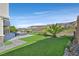 Manicured backyard with artificial turf, gravel landscaping, mountain views and pool at 1320 Enchanted River Dr, Henderson, NV 89012
