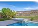 Relaxing backyard featuring a hot tub, professional landscaping, and a view of the surrounding mountains at 1320 Enchanted River Dr, Henderson, NV 89012