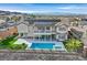 Luxury backyard with a sparkling pool, spa, covered patio, and solar panels on the roof with mountain views at 1320 Enchanted River Dr, Henderson, NV 89012