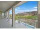 Covered balcony with view of mountains, neighborhood, and luscious green golf course at 1320 Enchanted River Dr, Henderson, NV 89012