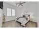 Bright, white bedroom with a window, ceiling fan, and wood flooring at 1320 Enchanted River Dr, Henderson, NV 89012