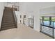 Bright entryway featuring staircase, modern railings, and views of pool through large windows at 1320 Enchanted River Dr, Henderson, NV 89012