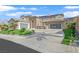 Expansive two-story home with a three-car garage, desert landscaping, and a circular driveway at 1320 Enchanted River Dr, Henderson, NV 89012
