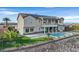 A beautiful two-story home with a sparkling pool, covered patio, and lush green lawn, perfect for outdoor living at 1320 Enchanted River Dr, Henderson, NV 89012