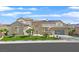 Beautiful two-story home featuring a manicured lawn, stone accents, modern garage door, and desert landscaping at 1320 Enchanted River Dr, Henderson, NV 89012