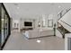 Expansive living room featuring modern fireplace, staircase, and access to outdoor spaces at 1320 Enchanted River Dr, Henderson, NV 89012