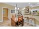 Dining room with wood floors, neutral walls, and a breakfast bar that opens to the kitchen at 1435 Orange Jubilee Rd, Henderson, NV 89014