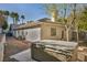 Backyard featuring a hot tub, brick accents, and lush tropical landscaping at 177 Knollwood Ct, Henderson, NV 89074