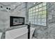 Bathroom features a luxurious soaking tub next to a fireplace and frosted window for optimal lighting and privacy at 177 Knollwood Ct, Henderson, NV 89074