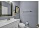 A well-lit powder room with a decorative mirror, single sink vanity, and neutral finishes at 177 Knollwood Ct, Henderson, NV 89074